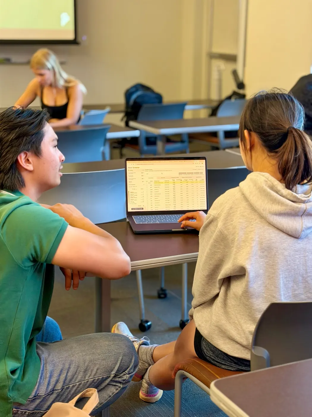 Students comparing information on a laptop
